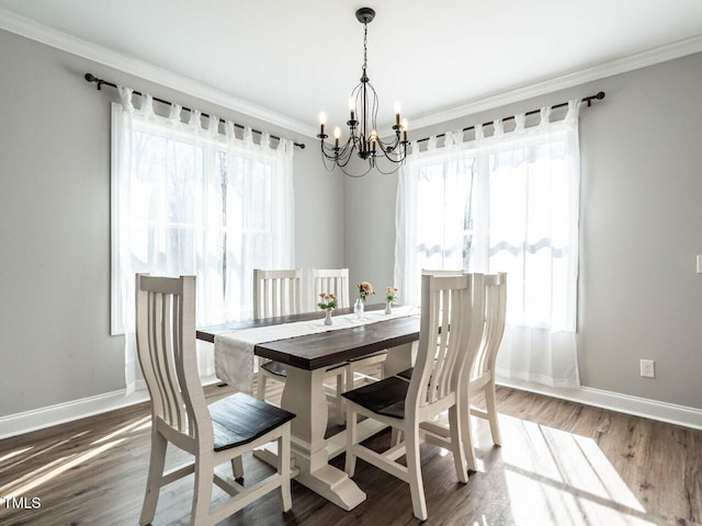 dining area featuring ornamental molding, a chandelier, and dark hardwood / wood-style floors