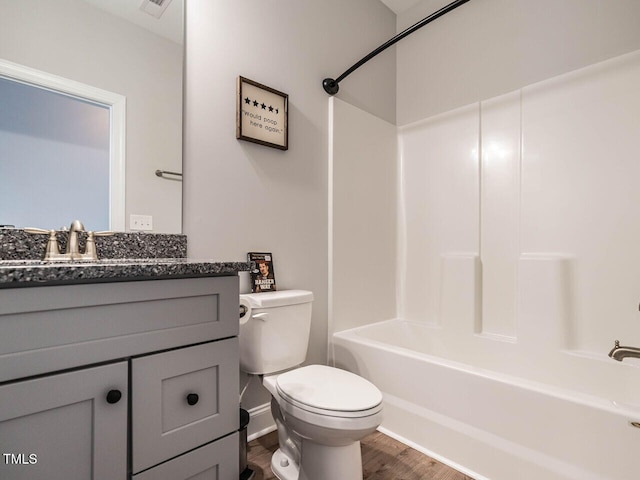 full bathroom featuring toilet, hardwood / wood-style flooring, bathtub / shower combination, and vanity