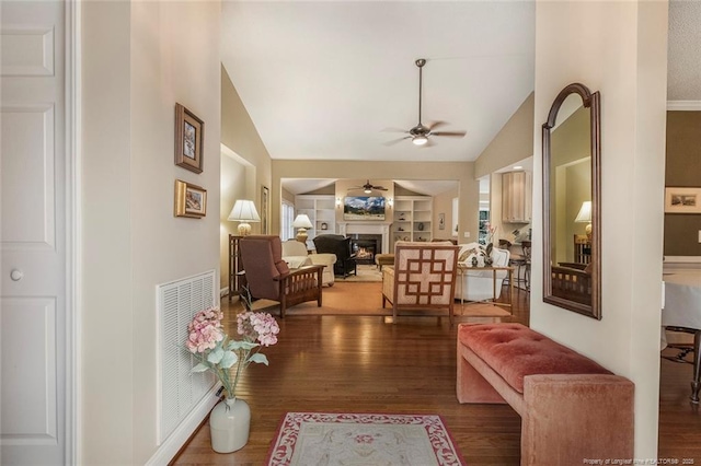 living room with built in shelves, dark wood-type flooring, ceiling fan, and lofted ceiling