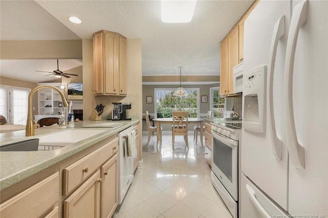 kitchen with sink, hanging light fixtures, white appliances, light brown cabinetry, and light tile patterned floors