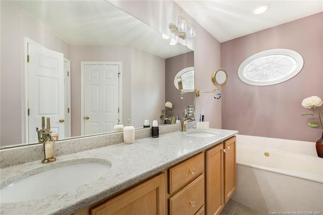 bathroom featuring tile patterned flooring, vanity, and a tub