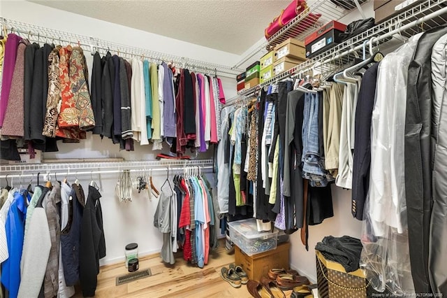 walk in closet with hardwood / wood-style floors