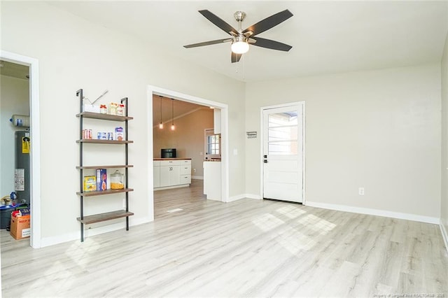 interior space featuring ceiling fan, gas water heater, lofted ceiling, and light hardwood / wood-style flooring