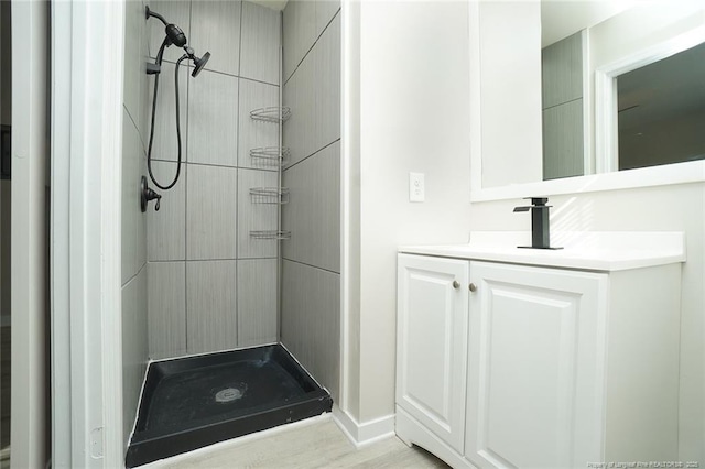 bathroom with vanity and tiled shower