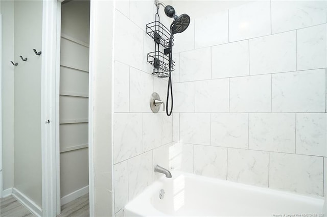 bathroom featuring wood-type flooring and tiled shower / bath combo