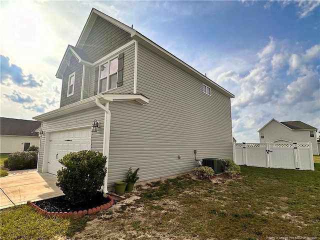 view of home's exterior featuring a lawn, a garage, and central air condition unit