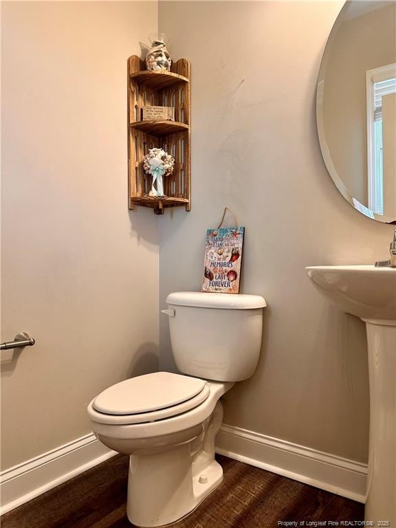 bathroom with hardwood / wood-style flooring, toilet, and sink