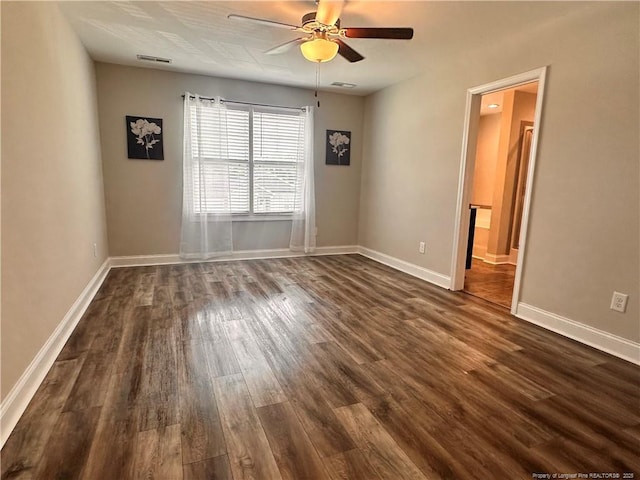 empty room featuring ceiling fan and dark wood-type flooring