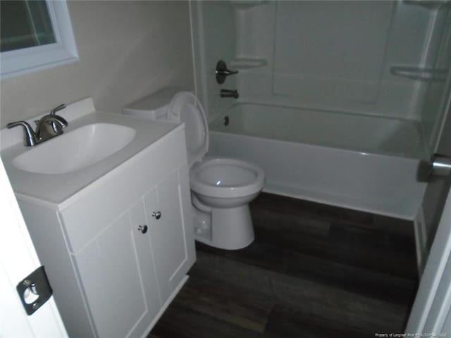 full bathroom with hardwood / wood-style flooring, vanity, shower / bathtub combination, and toilet