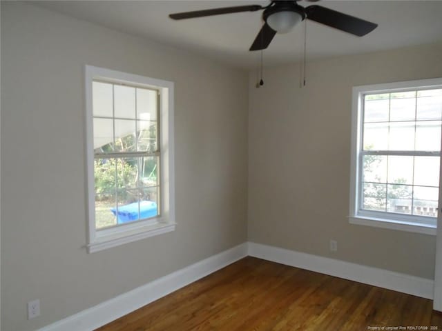 unfurnished room with ceiling fan and dark wood-type flooring