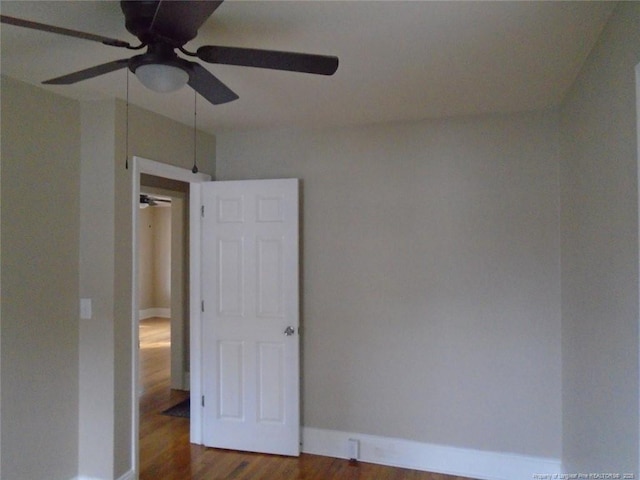 spare room with dark hardwood / wood-style flooring and ceiling fan