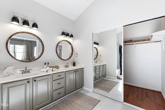 bathroom featuring lofted ceiling, vanity, and tile patterned flooring