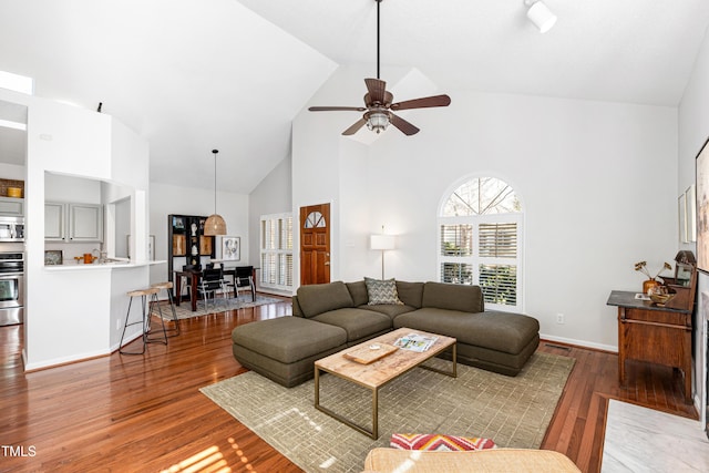 living room featuring hardwood / wood-style flooring, high vaulted ceiling, and ceiling fan