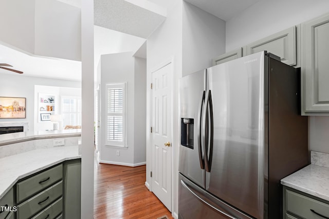 kitchen featuring ceiling fan, stainless steel fridge, and light wood-type flooring