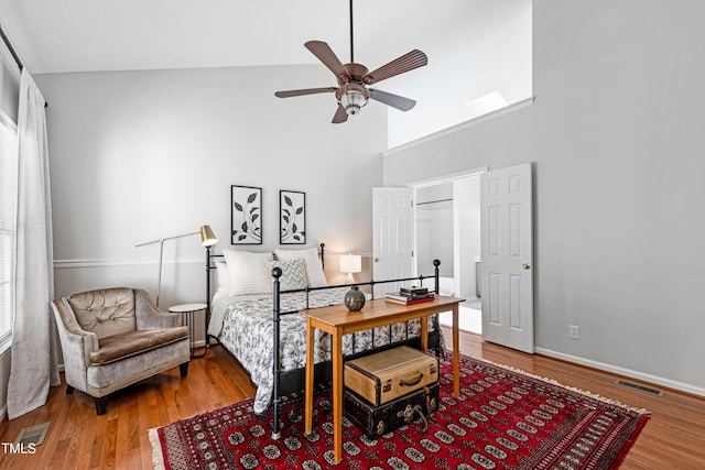 bedroom featuring hardwood / wood-style flooring, high vaulted ceiling, and ceiling fan