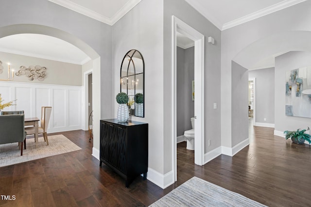 corridor featuring ornamental molding, dark wood-type flooring, and a notable chandelier