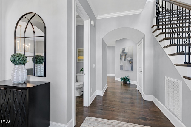 corridor featuring dark wood-type flooring and ornamental molding