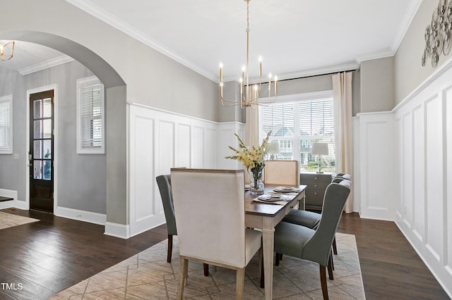 dining area featuring ornamental molding, dark wood-type flooring, and a notable chandelier