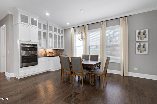 dining space with crown molding, dark wood-type flooring, and a notable chandelier