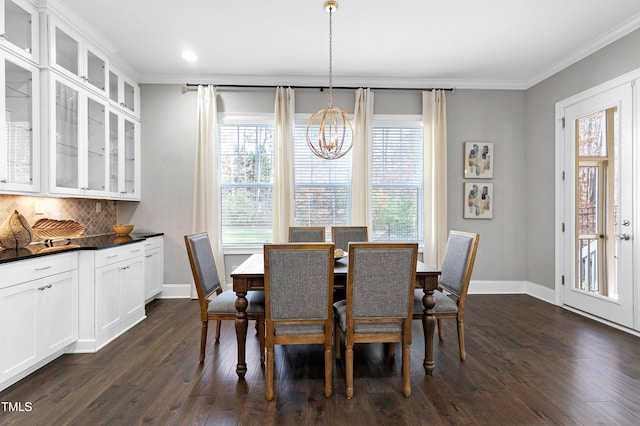 dining space with a notable chandelier, ornamental molding, and dark hardwood / wood-style floors