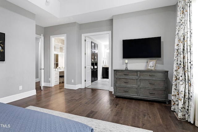 bedroom featuring connected bathroom and dark hardwood / wood-style flooring