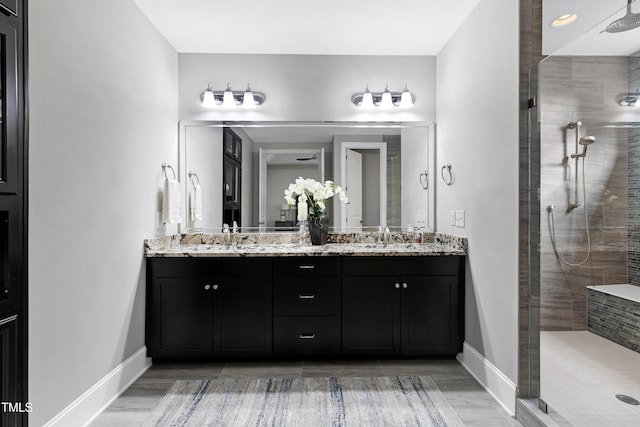 bathroom featuring a tile shower and vanity