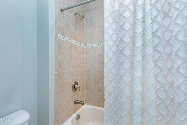 bathroom featuring shower / tub combo and toilet