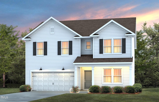 view of front facade featuring a garage and a yard