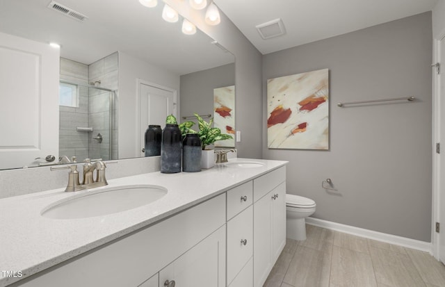 bathroom featuring toilet, an enclosed shower, and vanity