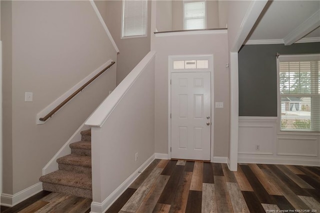 entrance foyer featuring ornamental molding and dark wood-type flooring