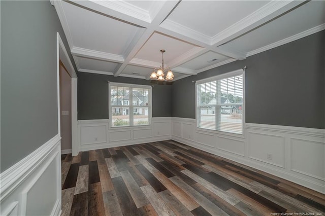 spare room with beamed ceiling, dark hardwood / wood-style flooring, an inviting chandelier, and ornamental molding