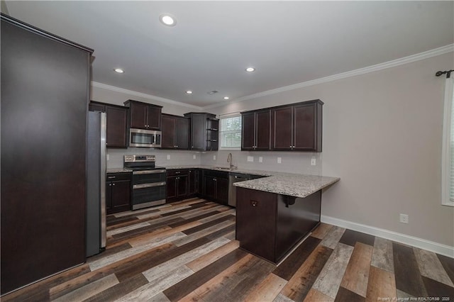 kitchen featuring dark wood-type flooring, stainless steel appliances, and ornamental molding