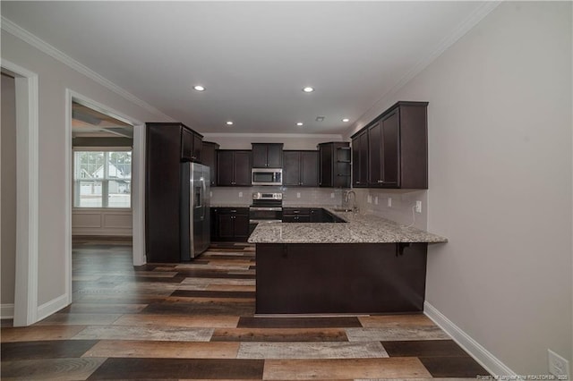 kitchen with a breakfast bar area, decorative backsplash, dark hardwood / wood-style flooring, kitchen peninsula, and stainless steel appliances