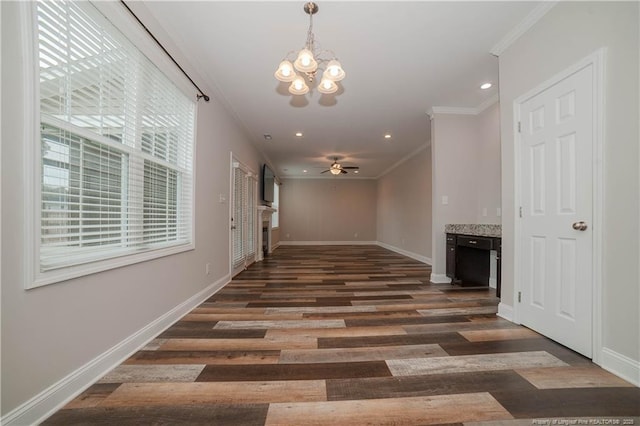 interior space with dark wood-type flooring, crown molding, and a notable chandelier