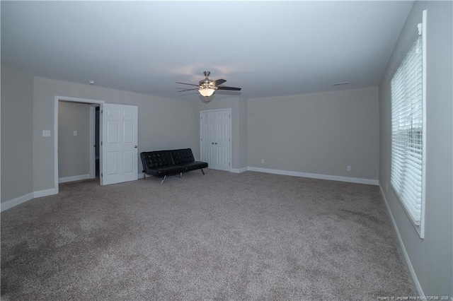 unfurnished living room with ceiling fan and carpet floors