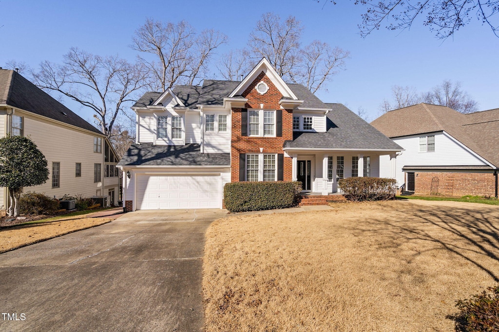 view of front of property featuring a garage and central air condition unit