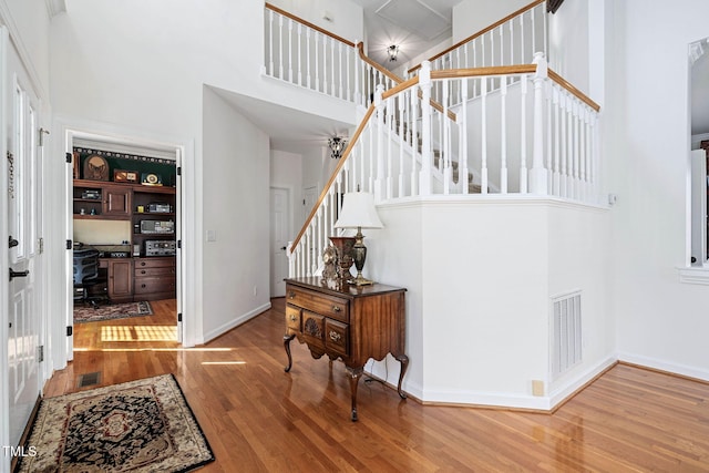 stairway with a high ceiling and hardwood / wood-style flooring