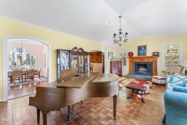 living room featuring a high end fireplace, vaulted ceiling, and a chandelier