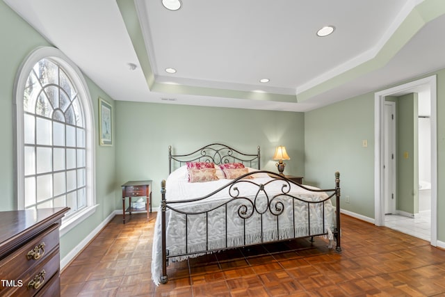 bedroom with dark parquet flooring and a tray ceiling