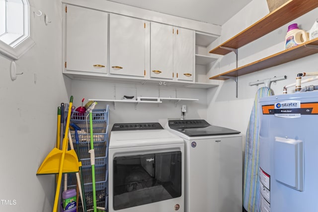 washroom with water heater, washer and clothes dryer, and cabinets