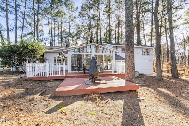 back of property with a deck and a sunroom