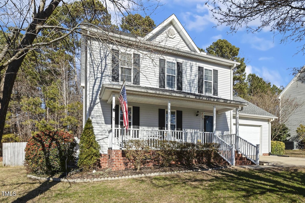 view of front of property featuring a porch, a front lawn, and a garage