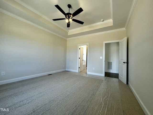 unfurnished bedroom featuring ornamental molding, a raised ceiling, visible vents, and baseboards