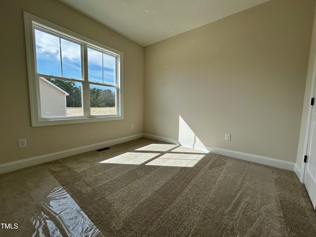 carpeted empty room featuring visible vents and baseboards