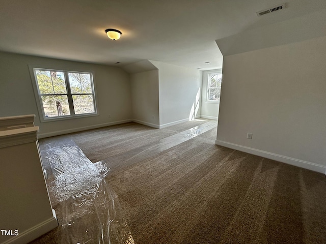 empty room featuring carpet flooring, visible vents, and baseboards