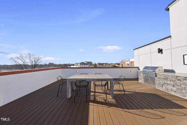 wooden terrace with exterior kitchen, exterior bar, and area for grilling