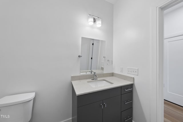 bathroom featuring vanity, hardwood / wood-style flooring, and toilet