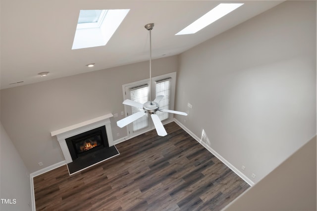 unfurnished living room with vaulted ceiling, dark hardwood / wood-style flooring, ceiling fan, and plenty of natural light