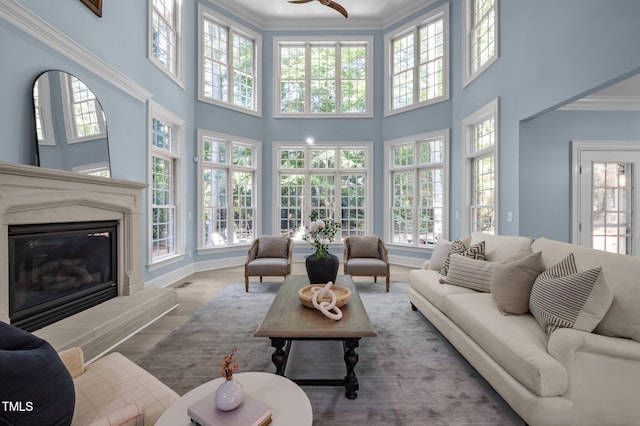 71012 Russell, Chapel Hill, NC 27517 - living area with crown molding, a glass covered fireplace, wood finished floors, a high ceiling, and ceiling fan