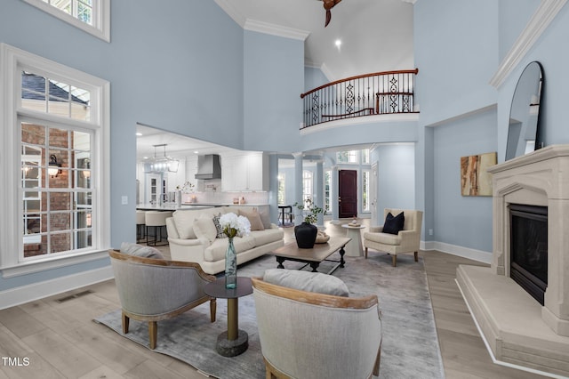 71012 Russell, Chapel Hill, NC 27517 - living area with a towering ceiling, baseboards, light wood-style floors, crown molding, and a glass covered fireplace